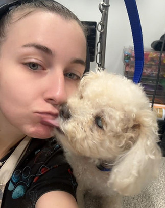 Fluffed Up groomer holding a freshly groomed dog