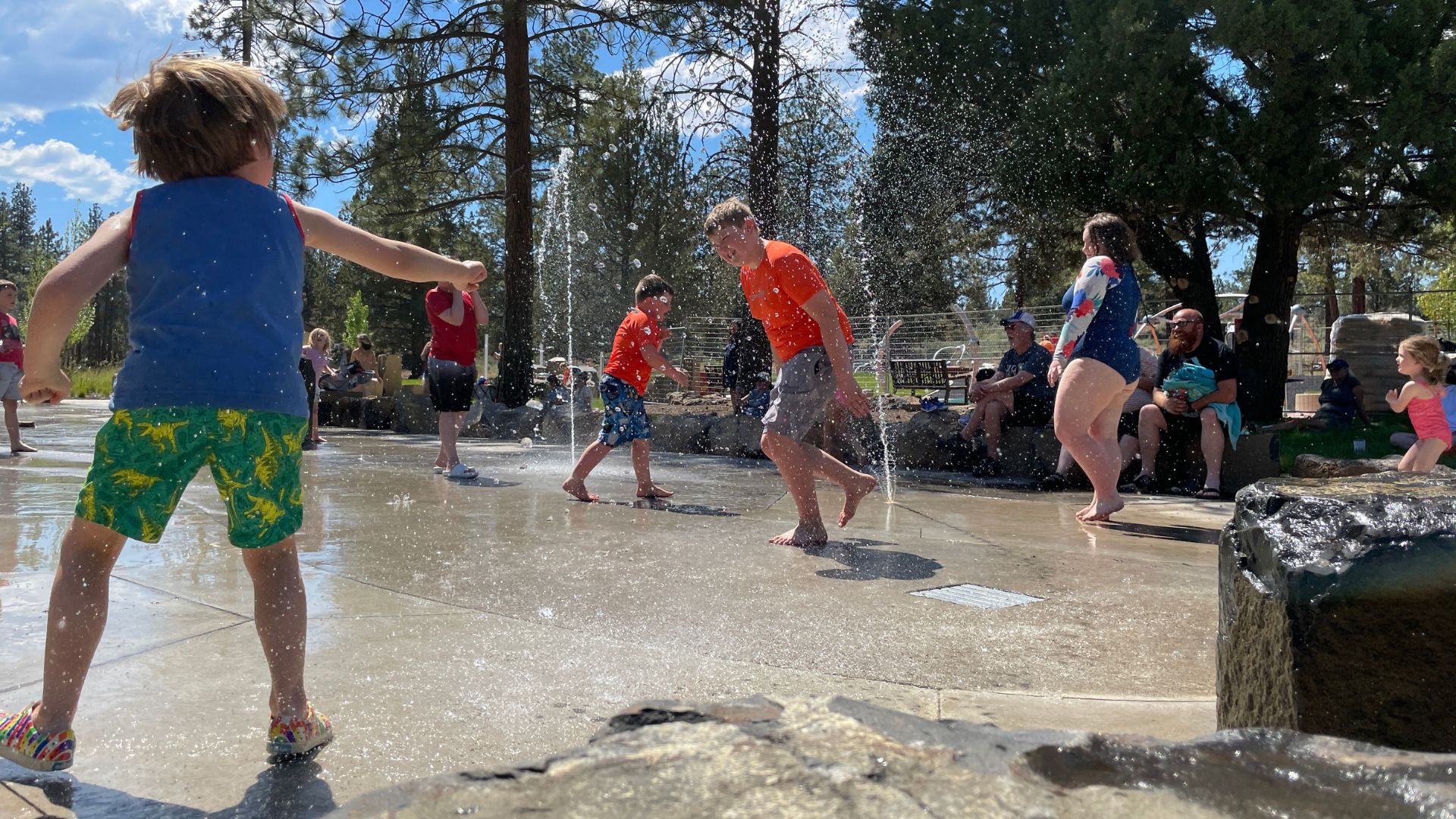 Children playing among spray features at Alpenglow Park.
