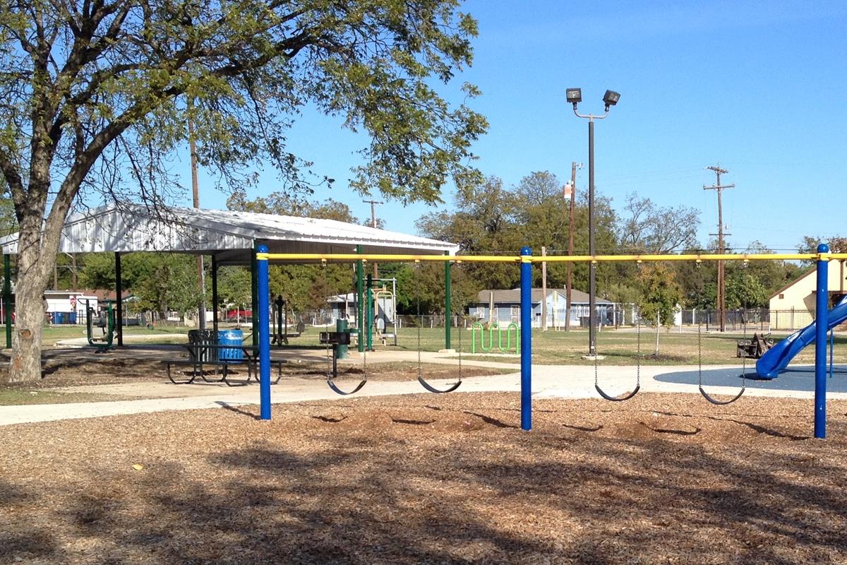 Playground swings and pavilion at Benavides Park.