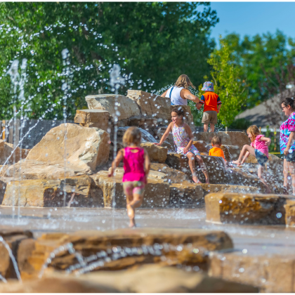 Children playing in the water feature at Berthoud Town Park.