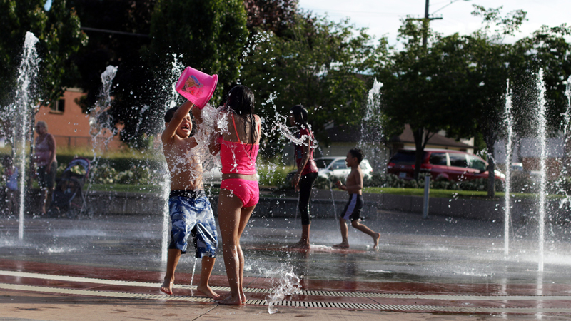 Kids running through water jets at Gresham Children's Fountain.