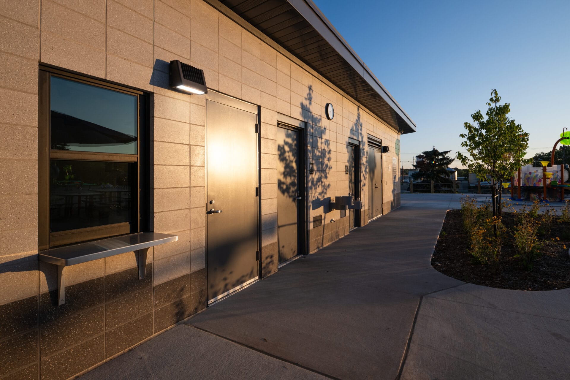 Shade structures and picnic tables beside aquatic center amenities in Kaukauna.