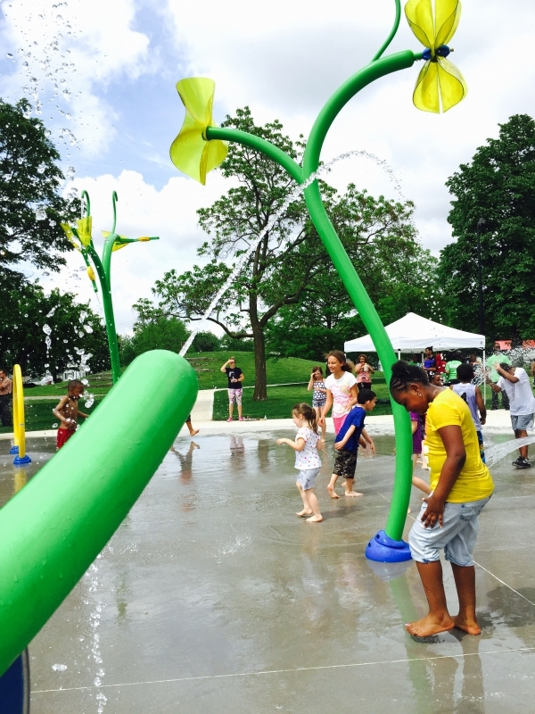 Wide view of the splash pad and surrounding park at Douglass Park