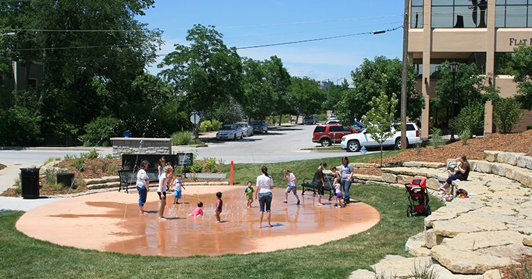 Children playing in the Flat Branch Spraygrounds with adult supervision.