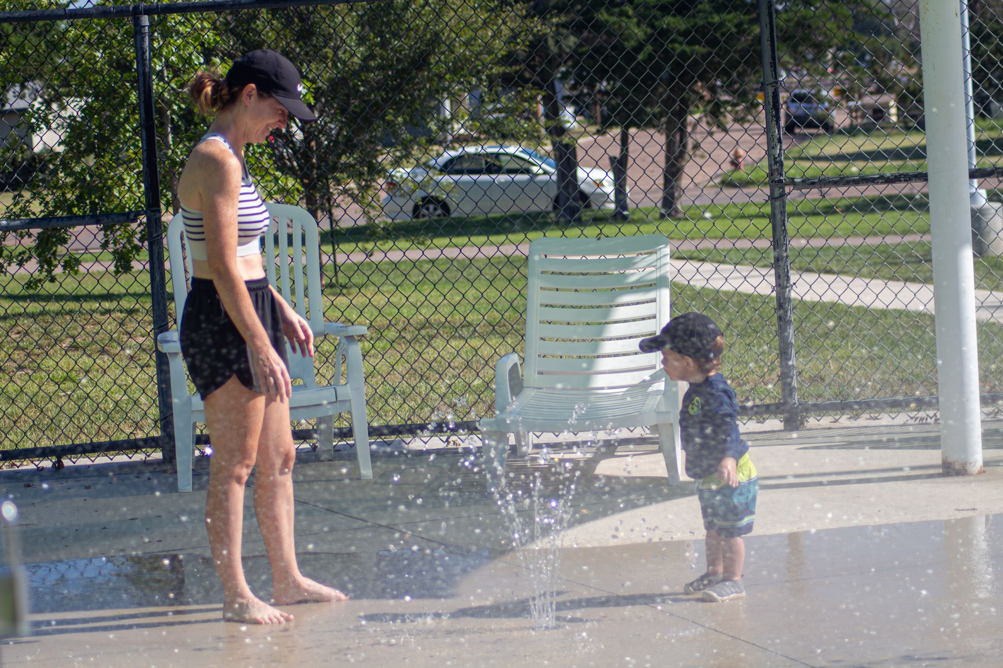 Child using a water feature at the Garden Rapids splash pad.