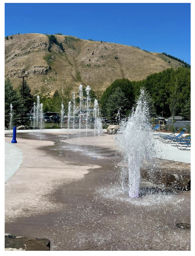 Interactive splash pad at Jackson Recreation Center with fountains and deck seating.