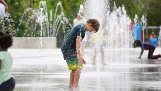 Water feature at John Chavis Memorial Park with child splashing.
