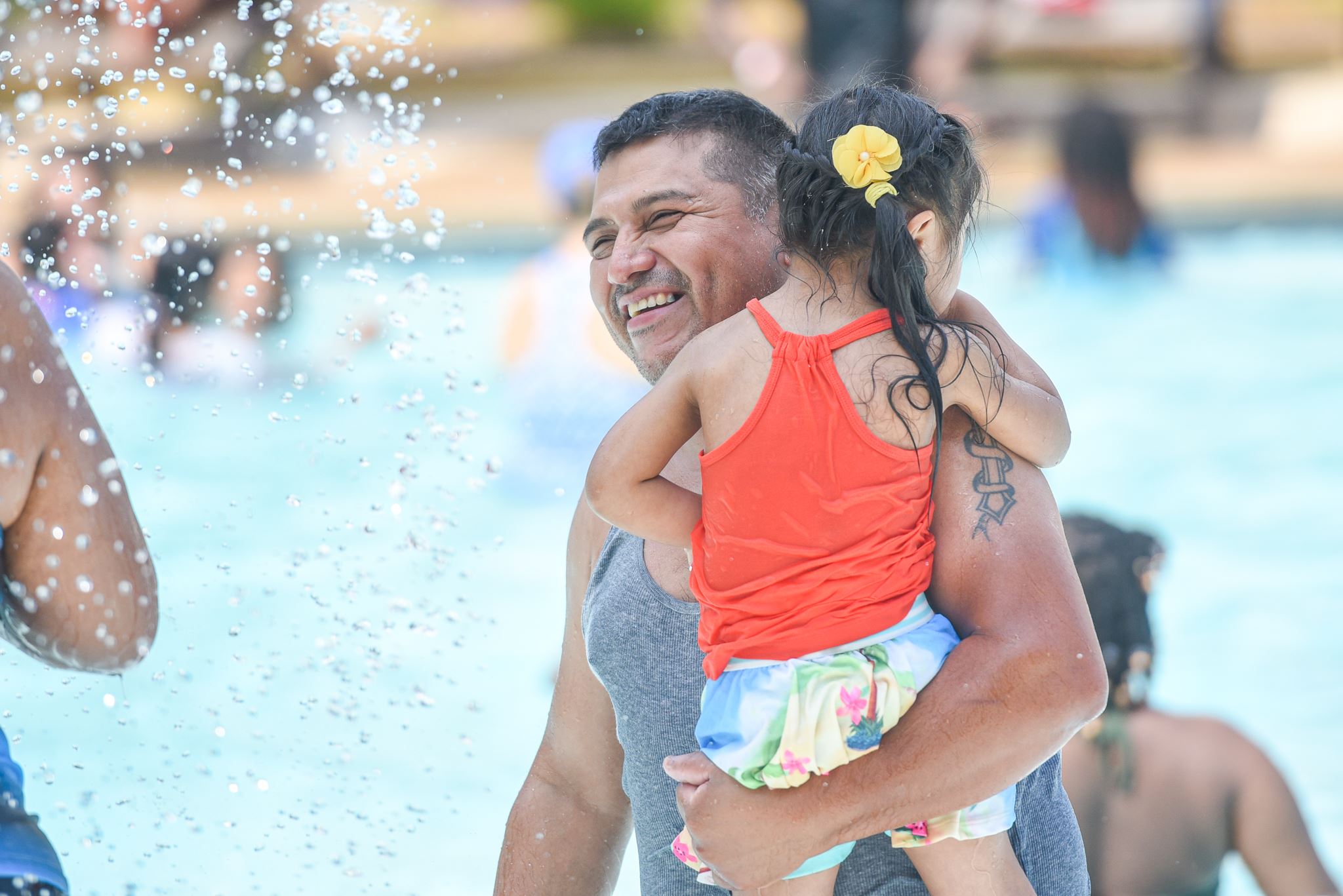Adult holding a small child in the family pool area at Dunn Municipal Pool.