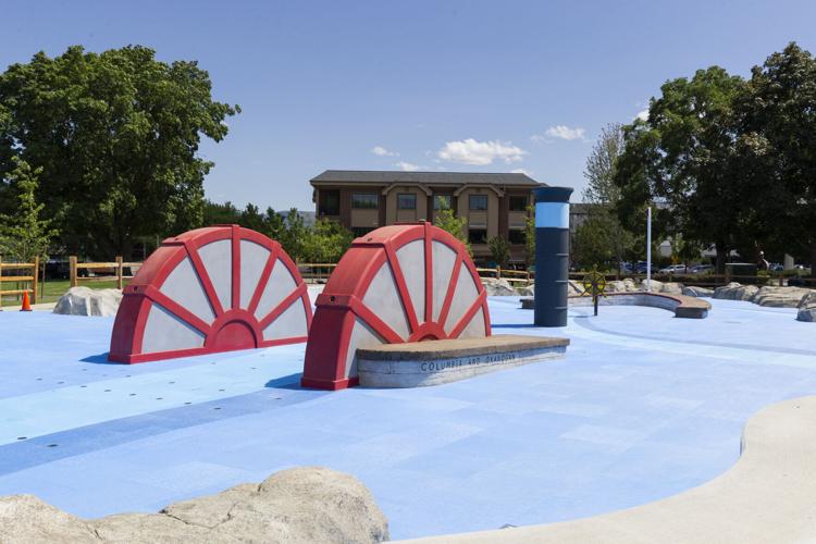 Public splash pad water sprays in a park environment.