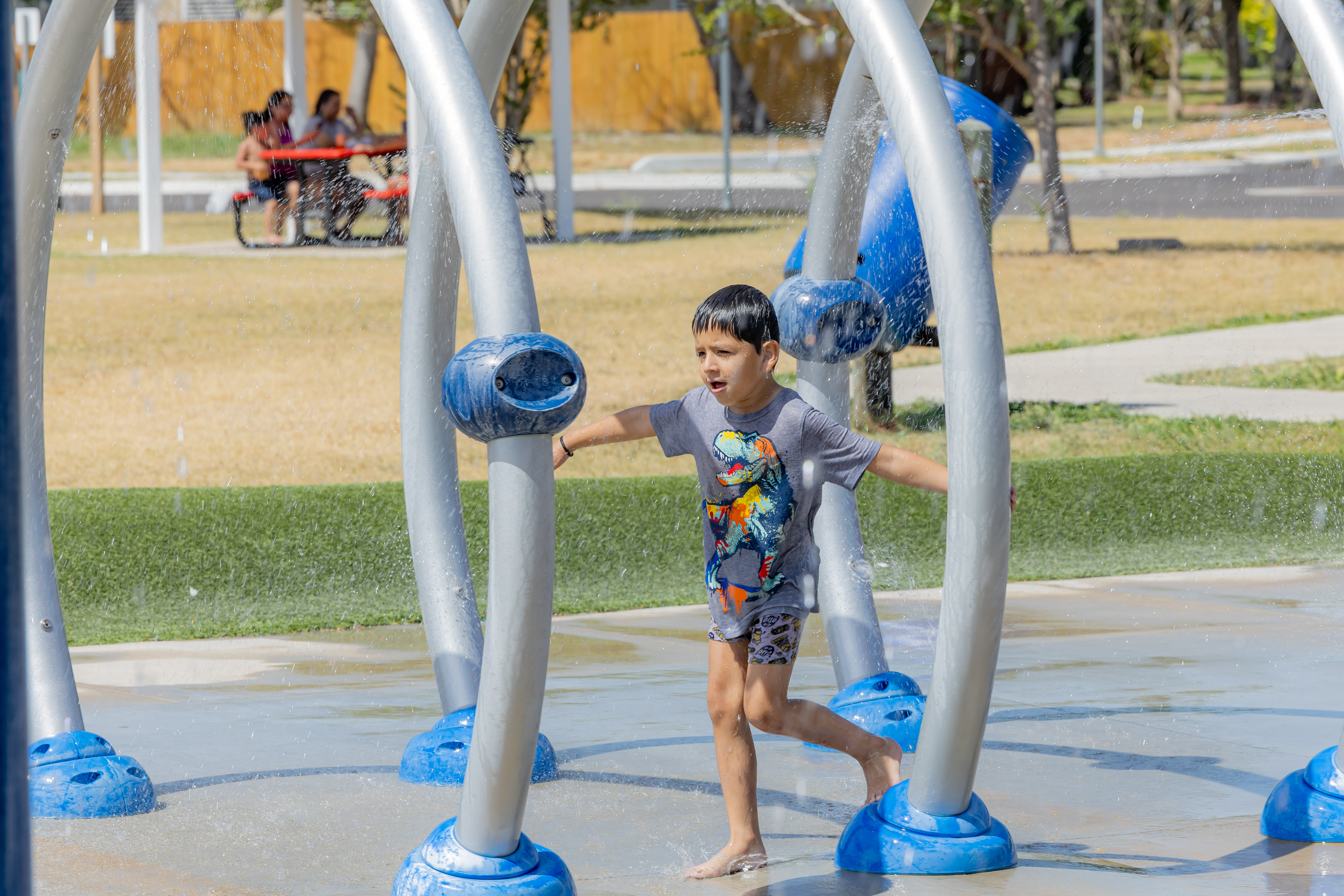 Child running through water at Lindale Park Splash Pad.