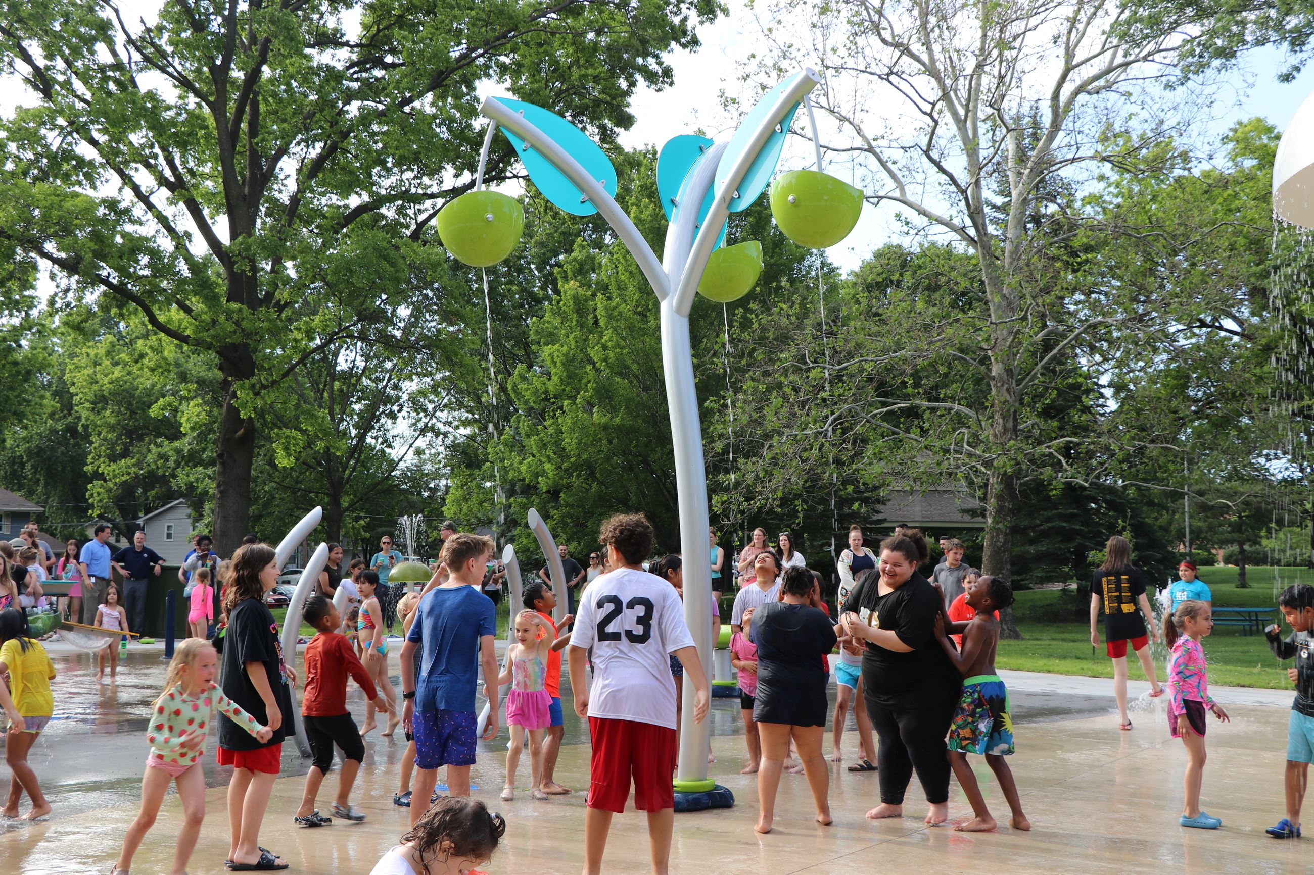 Kids gathered around the splash pad at Lions Park.