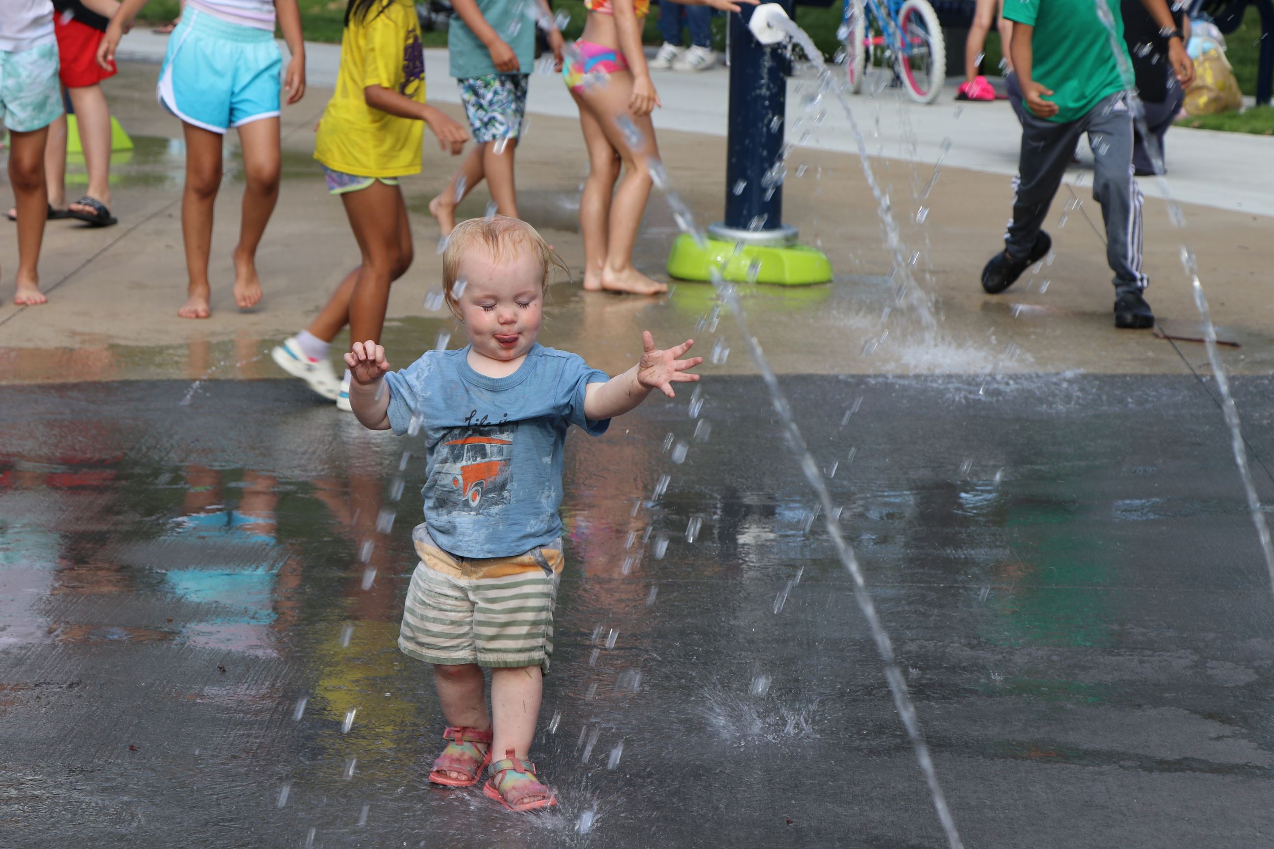 Young child stepping into the splash pad at Lions Park.