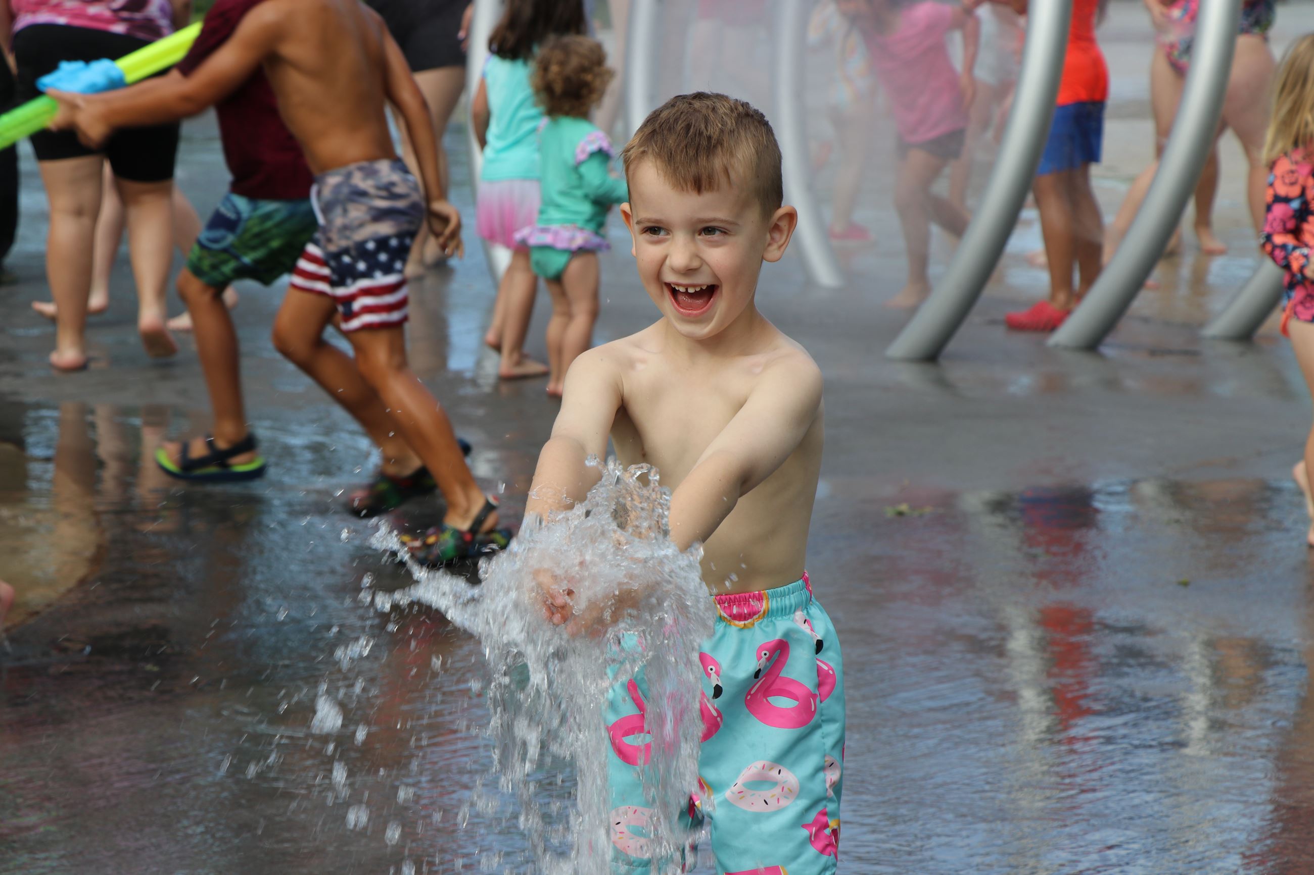 Child getting sprayed at Lions Park splash pad.