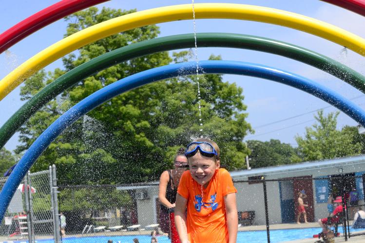 Child getting sprayed at the splash pad at Living Memorial Park.