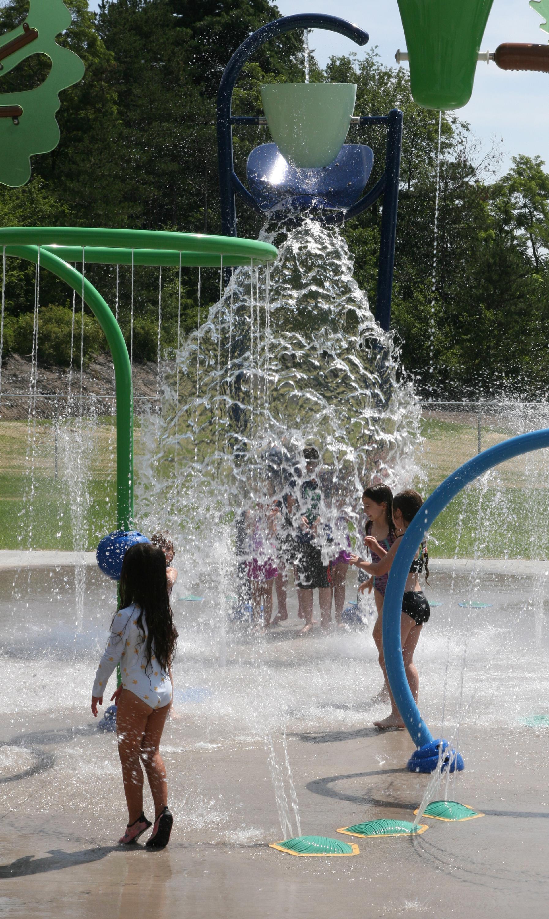 Children using spray features at McDade Park splash pad.