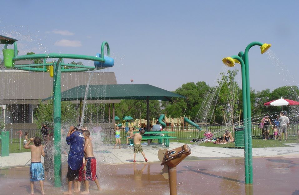 Children playing under a dumping bucket at Melio Gaspari Splash Park.