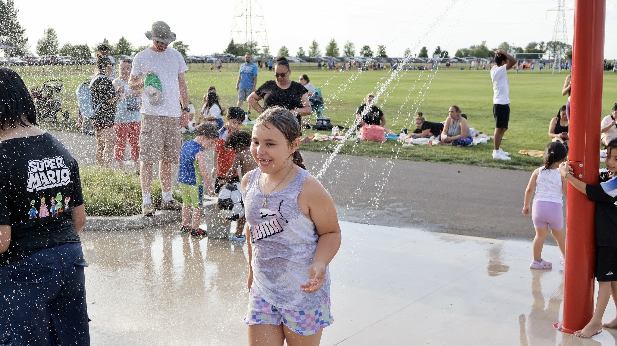 Children using the soak station water features near the playground.
