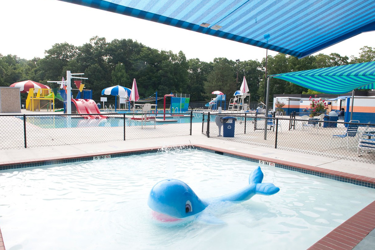 Kiddie pool at North Barnaby Splash Park with a whale fountain and shaded awning.
