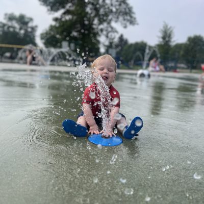 Children and families enjoying splash-pad water features in Minot.
