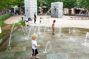 Children playing at Penrose Square water feature in Arlington.