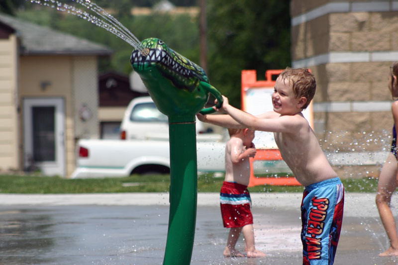 Child using a water cannon at Pioneer Splash Pad.
