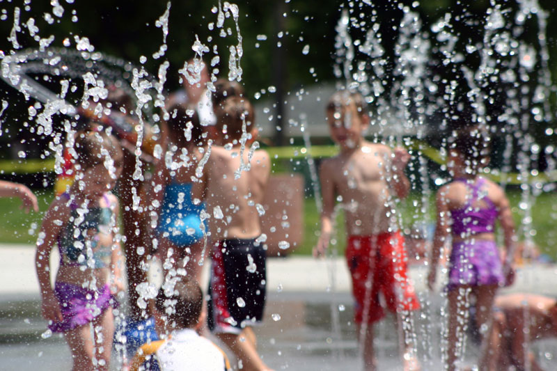 Kids running through splash features at Pioneer Splash Pad.