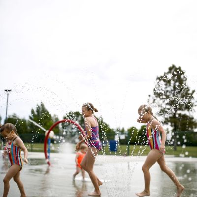 Kids playing in splash-pad fountains at a Minot park.