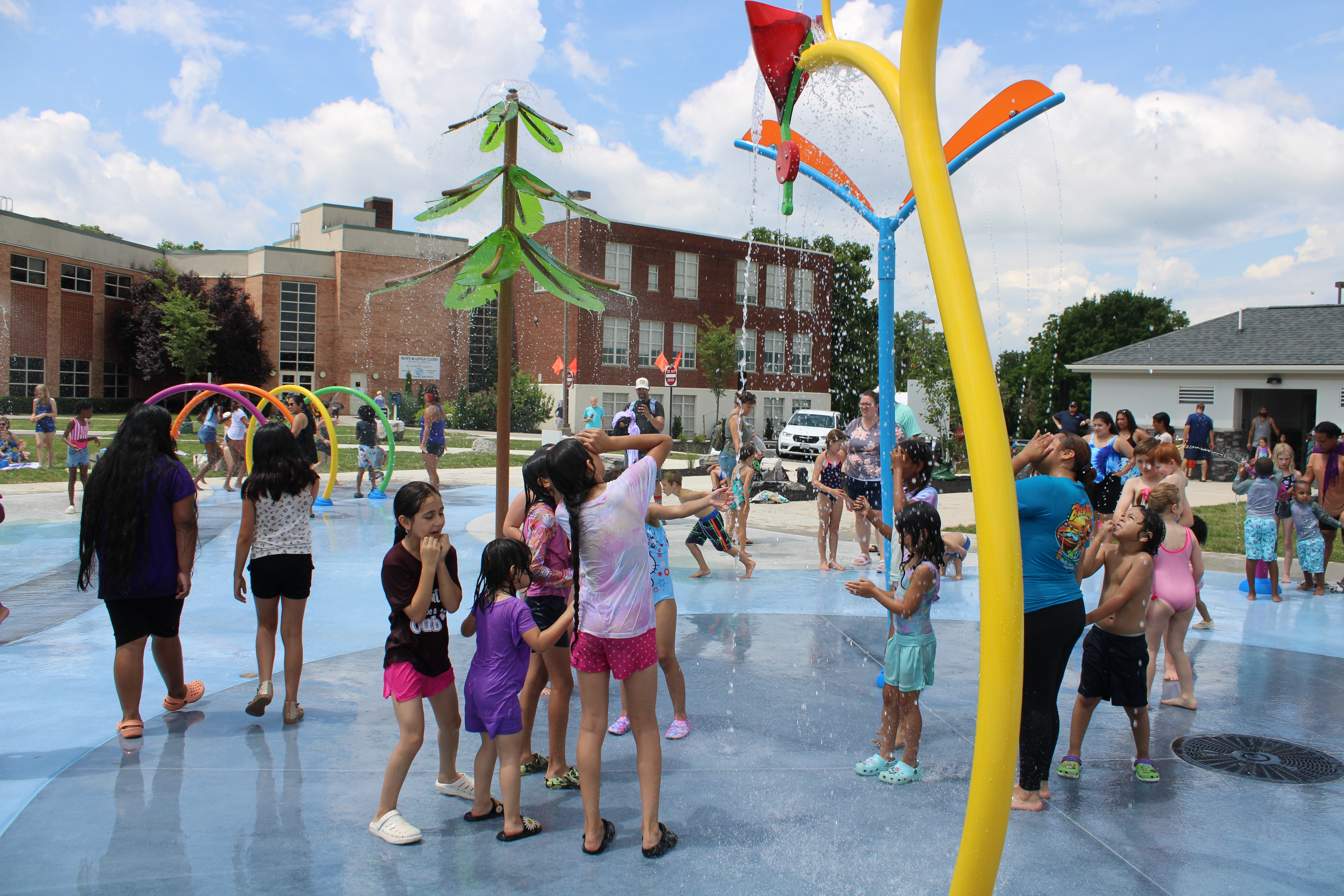 Families playing across the spraygrounds at Ralph Sampson Park.