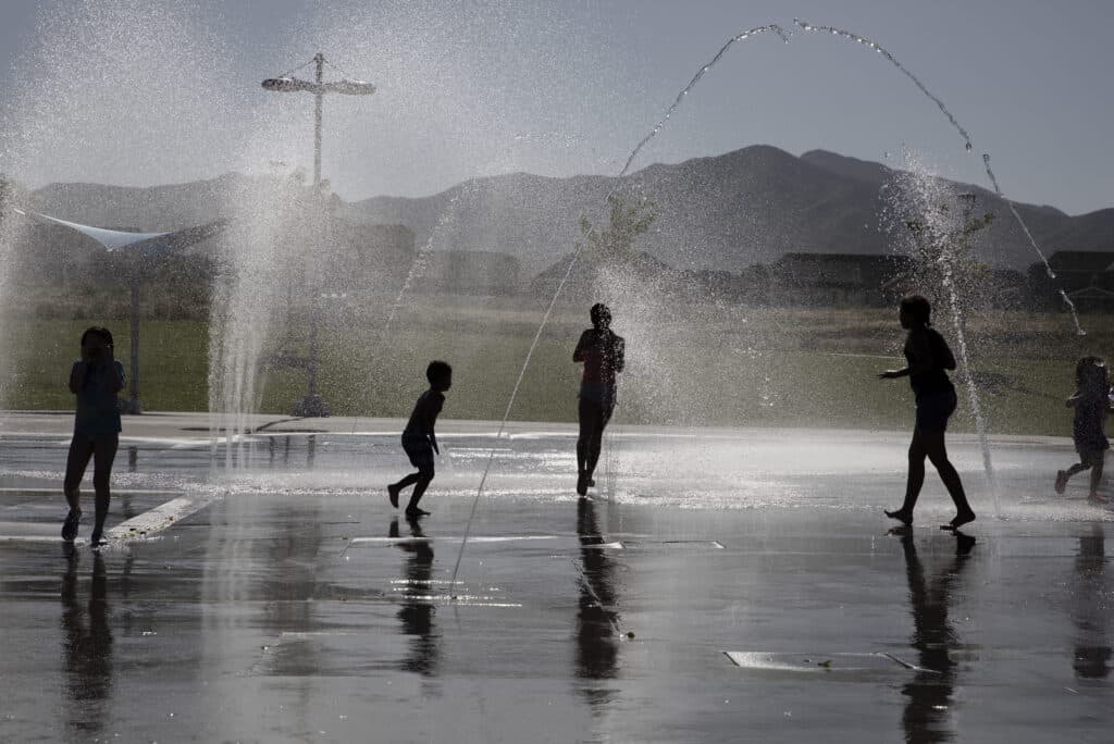 Children running through water jets at Ron Wood Park Splash Pad.