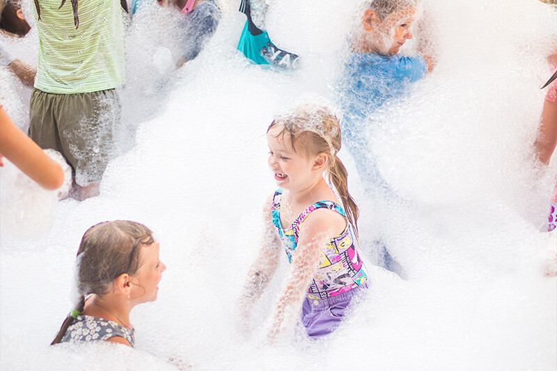 Kids enjoying a foam party setup promoted by The Alaska Club for private pool parties.