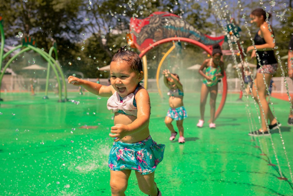 Children using water features in the Dinosaur Place splash pad.