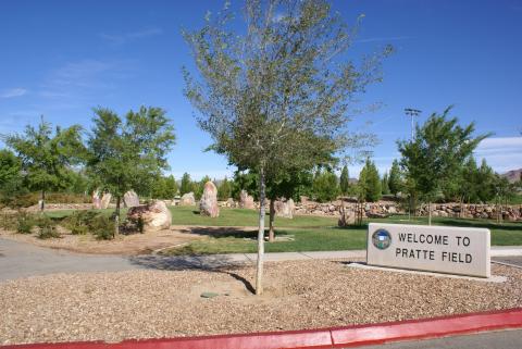 Open green area and welcome sign at Veterans Memorial Park in Boulder City.