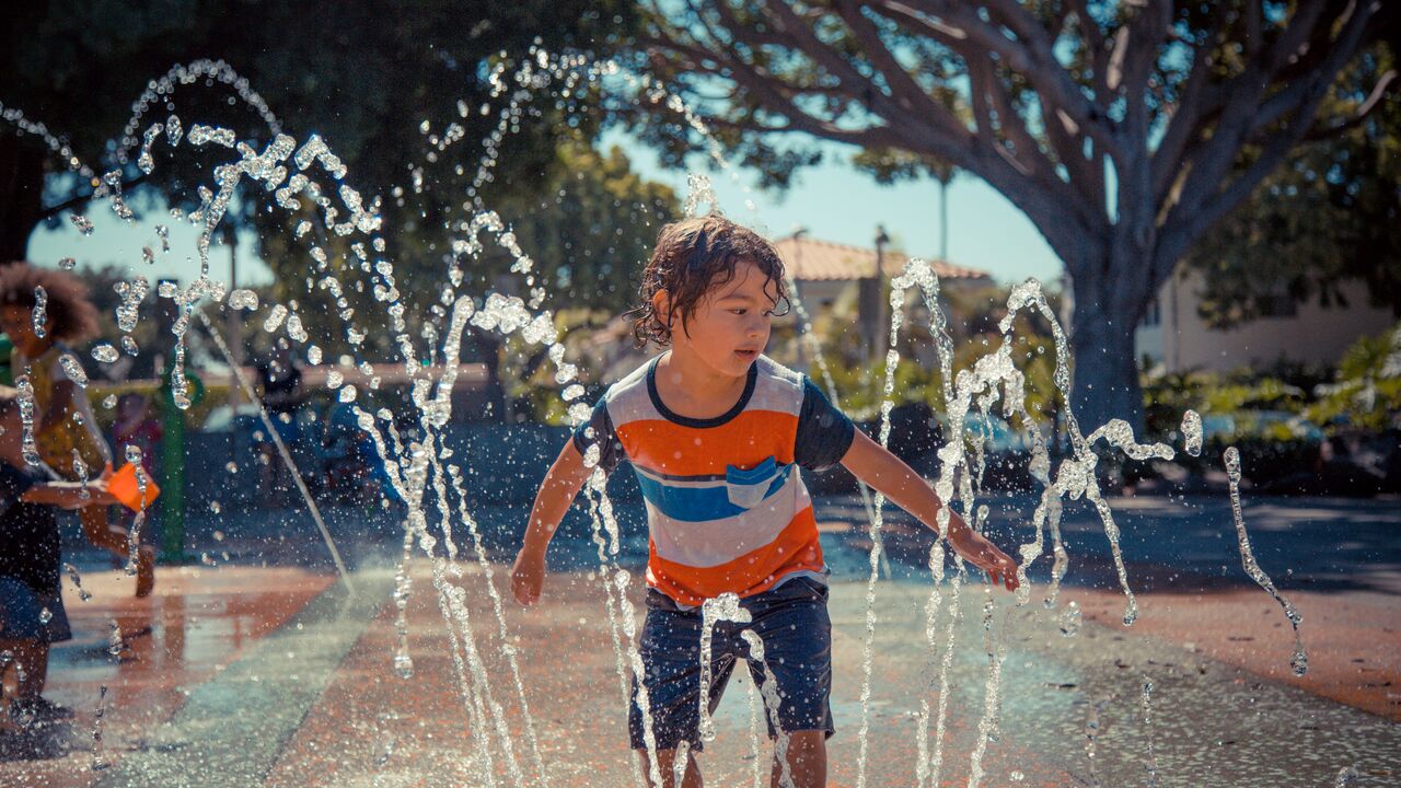 Young boy playing in the splash pad at Virginia Avenue Park.