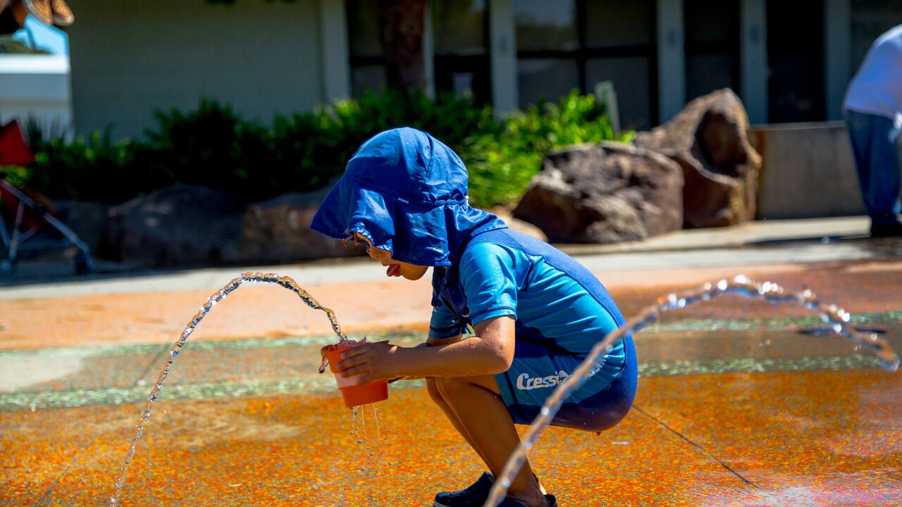 Young boy with bucket at the Virginia Avenue Park splash pad.
