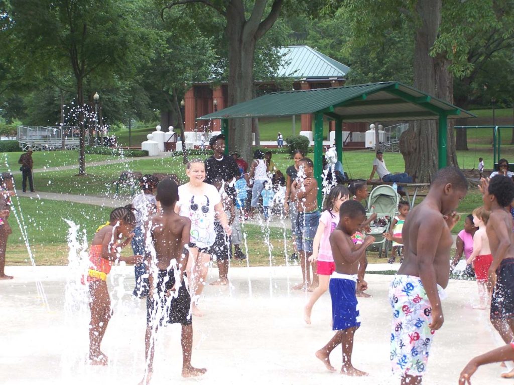 Children playing in Anniston splash pad sprays.